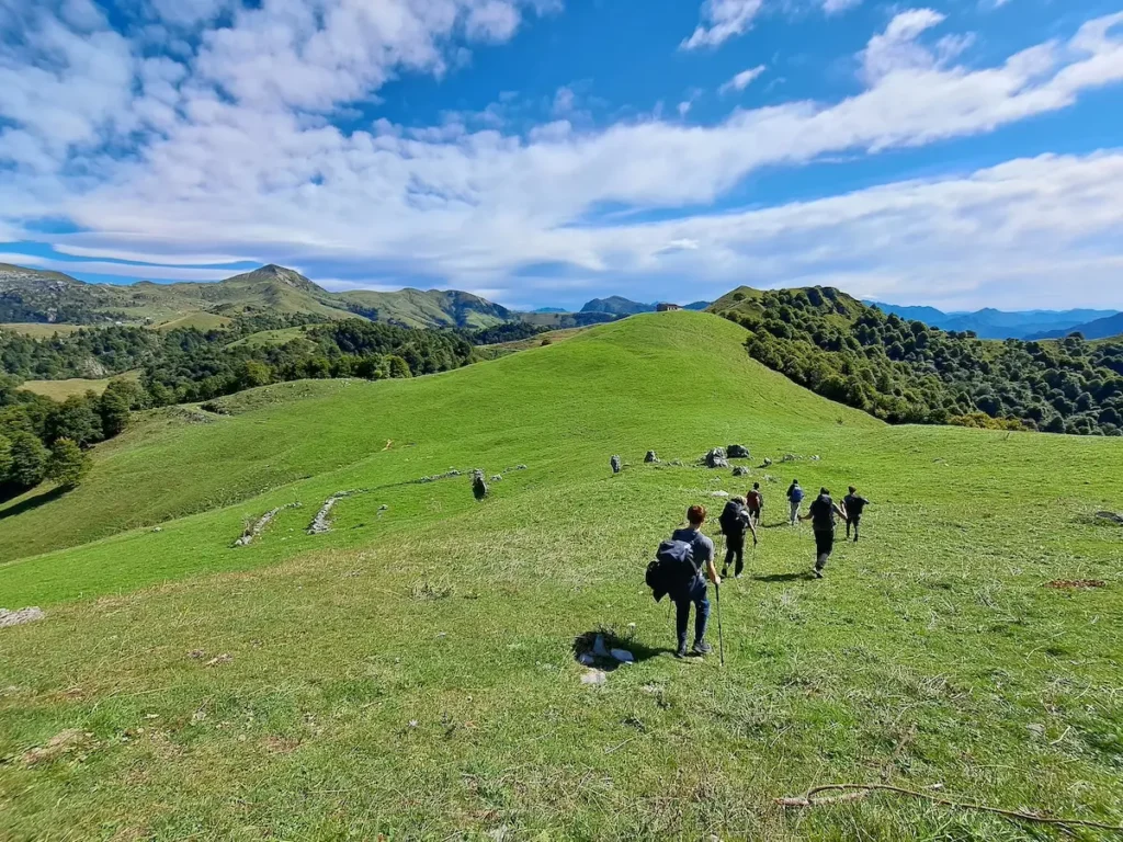 Persone che camminano lungo un sentiero sul Lago di Como, circondate dalla natura